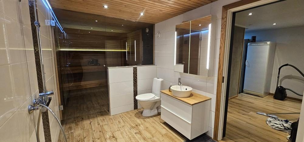 Iso kylpyhuone, lasiseinäinen sauna ja laatoitettu suihku Tampereella